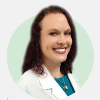 Christi Clark, hearing care professional wearing a white coat with a green background.