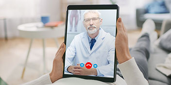 Online hearing care consultation with a HearingLife professional displayed on a tablet.