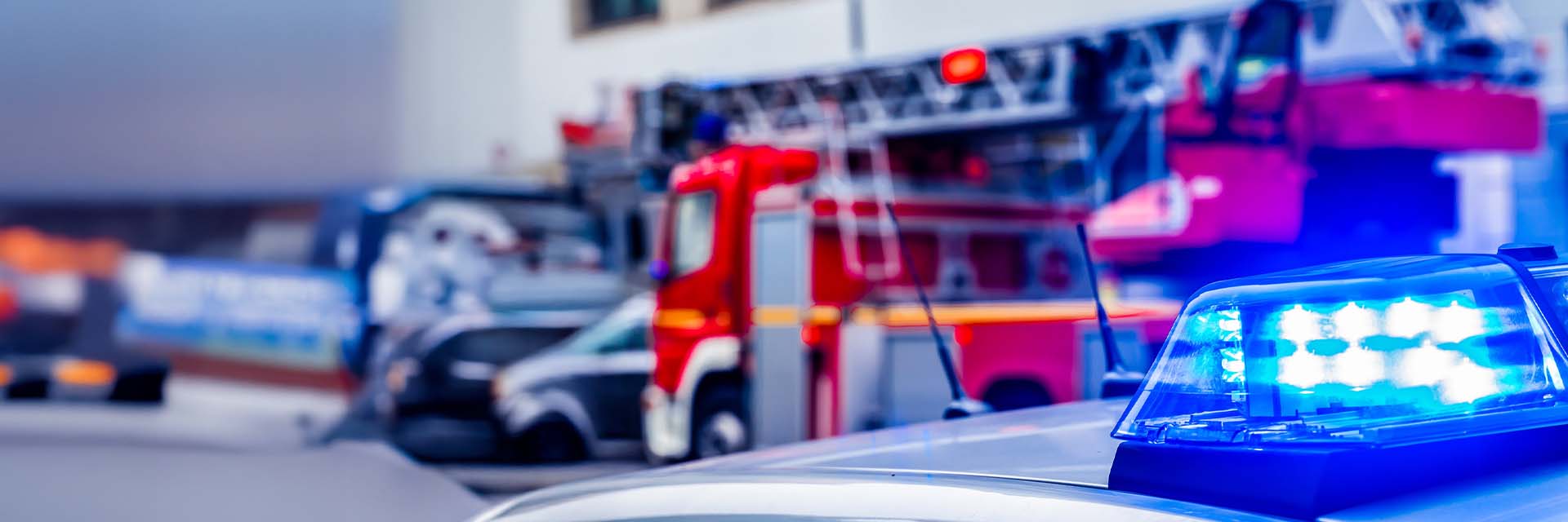 Emergency response vehicles with active flashing lights and sirens in a city setting