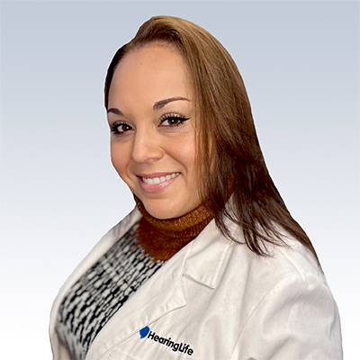 Aida Vargas, hearing care professional, wearing a white HearingLife lab coat.