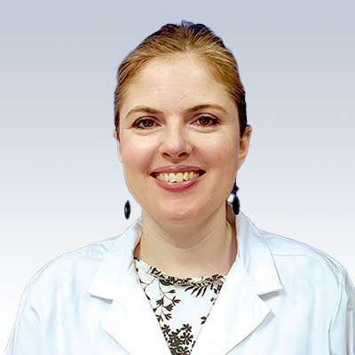 Hearing care professional wearing a white coat with a patterned blouse underneath.