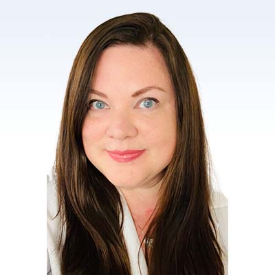 Amy Johnston, hearing care specialist with long brown hair wearing a white coat.