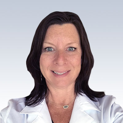 Amy Tomlinson, hearing care professional, wearing a white coat against a gradient background.