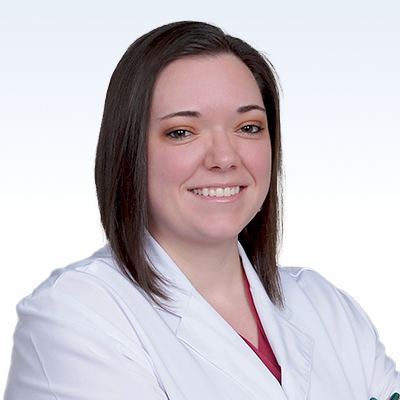 Ashlee Hart, hearing care professional in a white coat with crossed arms.