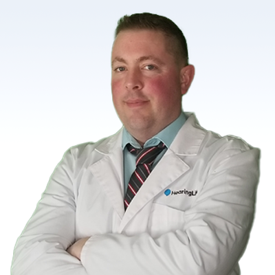 hearing care professional in a white lab coat with a HearingLife logo