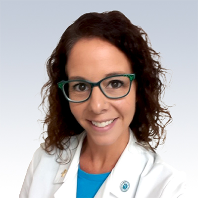 Christie Smith, hearing care specialist wearing a white lab coat with curly dark hair.