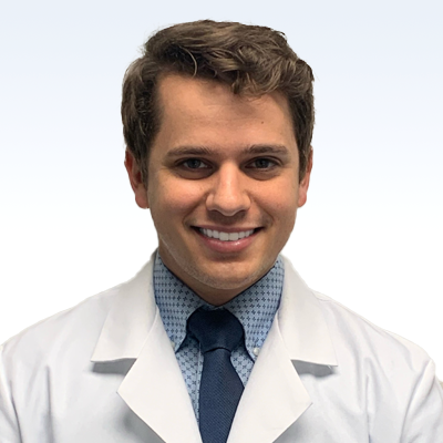 hearing care specialist wearing a white coat and blue tie