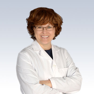 Diane Duffy wearing a white lab coat against a light gradient background.