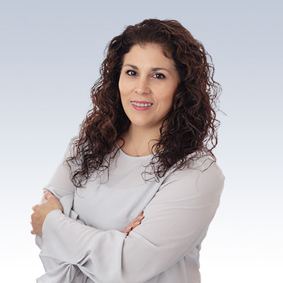 Esmeralda Barrientos posing with arms crossed in a professional setting.