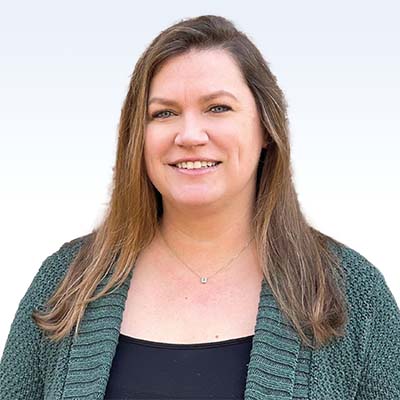 gail brown, hearing care specialist wearing a green cardigan and black top