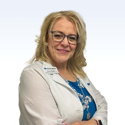 Hearing care professional wearing a white coat and a blue shirt with a floral design, representing HearingLife.