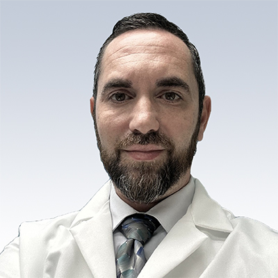 Hearing care professional wearing a white lab coat and tie.