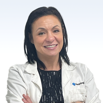 kathleen scheydt, hearing care specialist wearing a white coat with folded arms