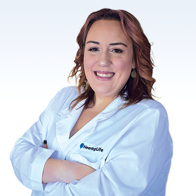 Hearing care professional wearing a white coat with the HearingLife logo.