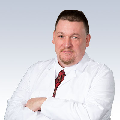 hearing care specialist in a white lab coat with arms crossed