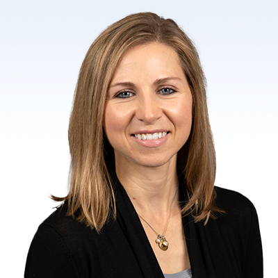 Kristin Hale, hearing care professional wearing a black cardigan and gold necklace, with shoulder-length blonde hair