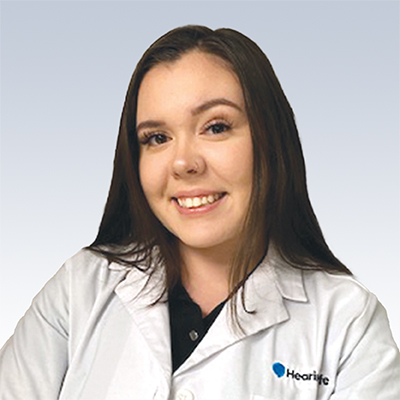 Hearing care professional wearing a white coat with the Hearlife logo.
