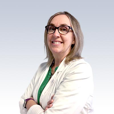 Laura Coffee, hearing care specialist, wearing a white coat and standing with arms crossed.