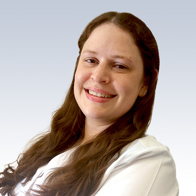 Lauren LeClercq, hearing care professional with long brown hair wearing a white coat against a light gradient background.
