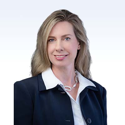 professional woman in business attire with long blonde hair wearing a navy blazer and white collared shirt