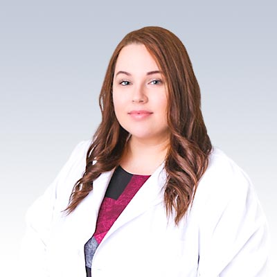 Malgorzata Saladra wearing a white coat against a light gradient background