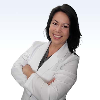 Megan Espinosa, hearing care professional wearing a white coat with arms crossed