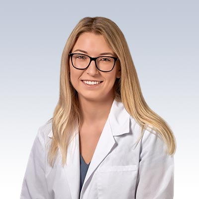 Megan Frank wearing a white lab coat against a neutral background