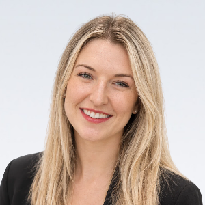 Professional wearing a white lab coat against a neutral background