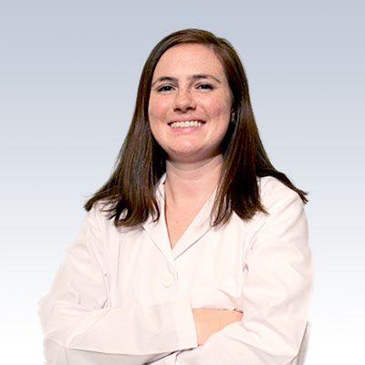 Megan Gustavson wearing a white coat with arms crossed against a light gradient background.