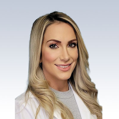 blonde hearing care professional wearing a white coat