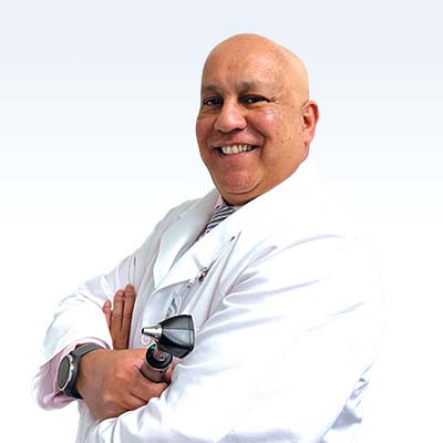 hearing care professional holding an otoscope wearing a white coat