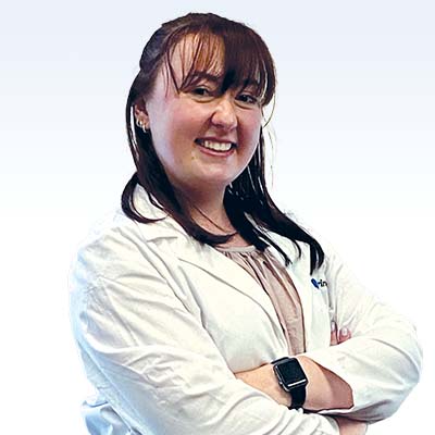 hearing care professional in a white coat with arms crossed