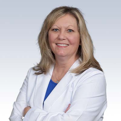 hearing care specialist wearing a white coat with arms crossed