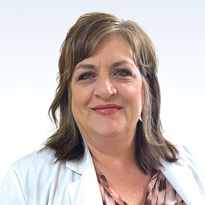 Regina Fromholt, hearing care professional wearing a white coat against a light background