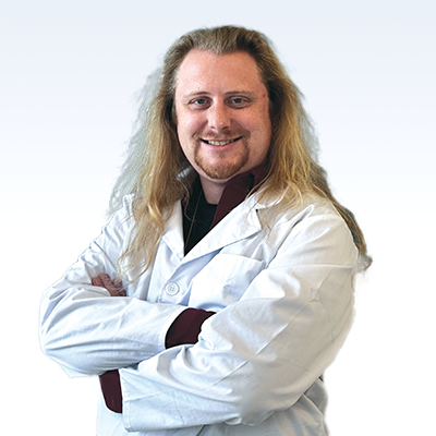 Hearing care professional in a white coat with arms crossed.