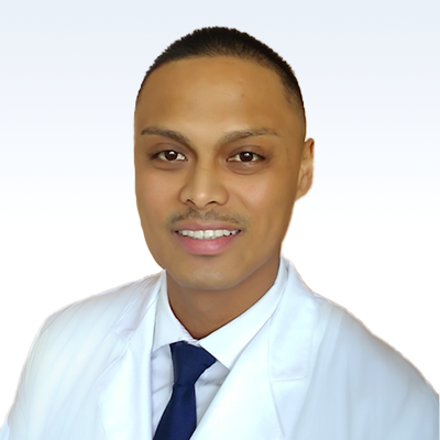 Hearing care professional Ritchie Blanco wearing a white coat and blue tie