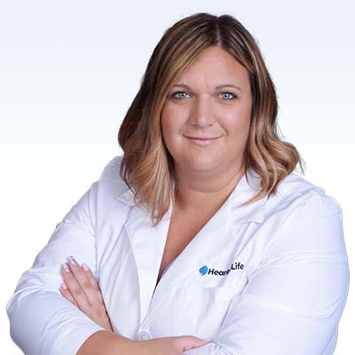 hearing care specialist in a white coat with crossed arms, representing HearLife brand