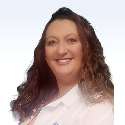 Sarah Thomas, hearing care specialist with long curly hair wearing a white coat
