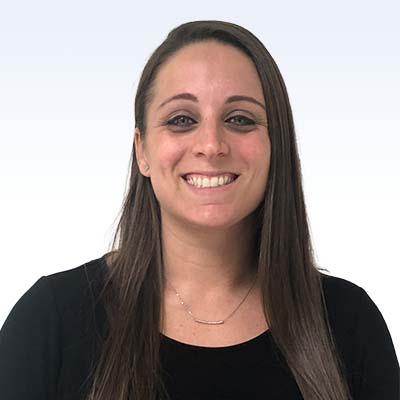 hearing care specialist with long brown hair wearing a black top and a silver necklace