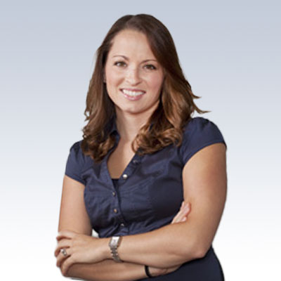 Stephanie Russo, hearing care professional smiling with arms crossed in a navy blouse.