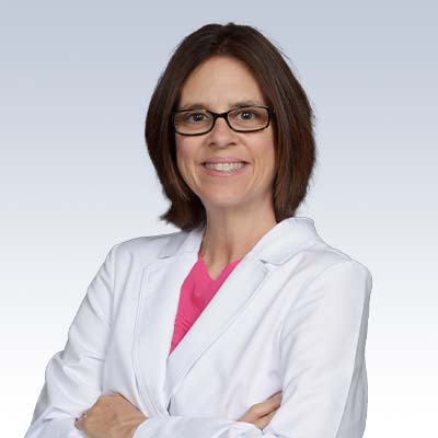 hearing care professional in a white coat with arms crossed