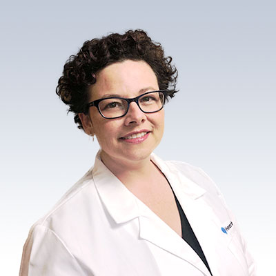 Terri Allen wearing a white lab coat with a blurred face.