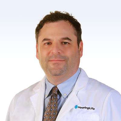 HearingLife professional in white coat and tie.