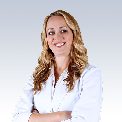 Trisha Huffman wearing a white coat with arms crossed against a gradient background.