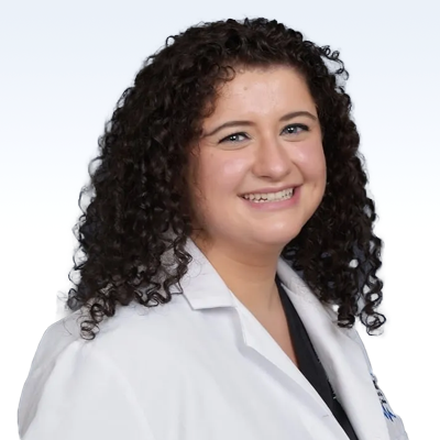 Curly-haired hearing care professional wearing a white lab coat