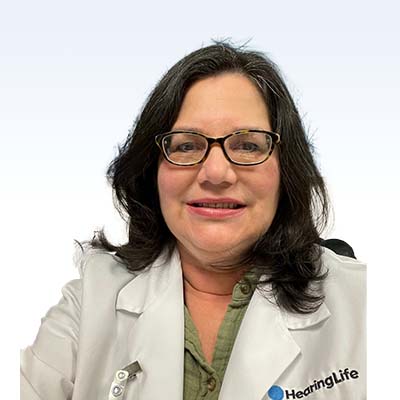 Hearing care specialist wearing a white coat with a HearingLife logo.