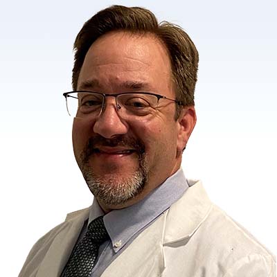 Hearing care specialist William Martin in a white coat and tie