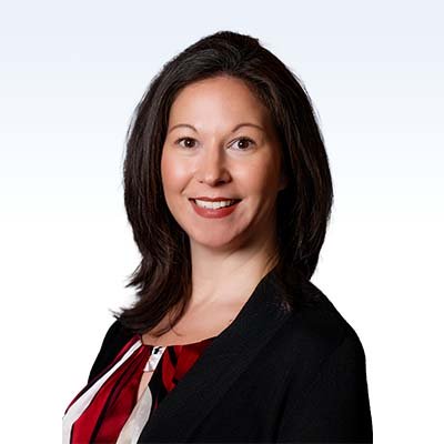 Abby Connell, hearing care professional wearing a red and black outfit against a light background