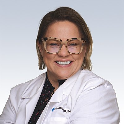 Hearing care professional wearing a white coat with HearingLife logo.