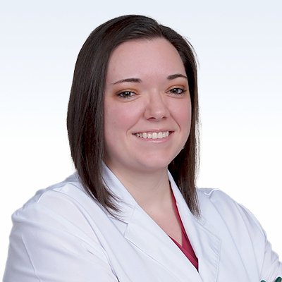 Ashlee Hart, hearing care professional in a white coat with crossed arms.